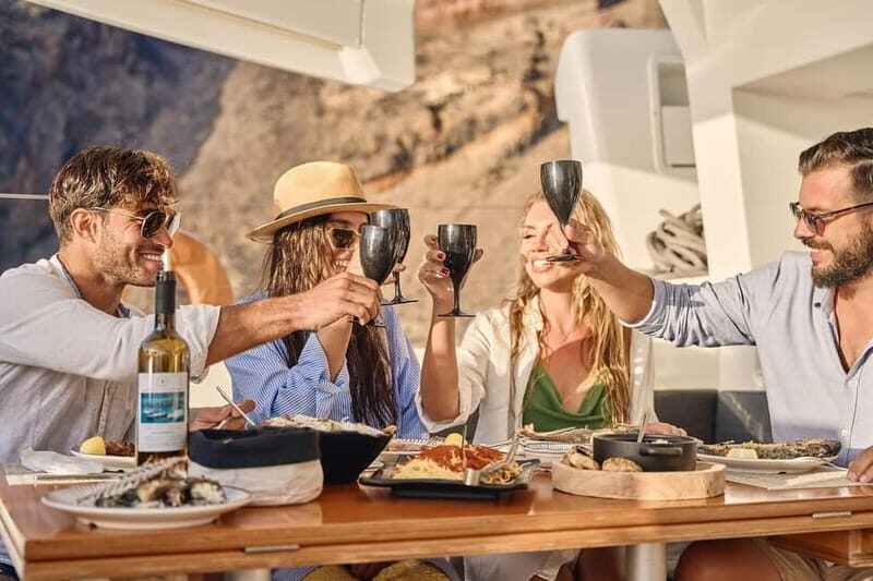 Santorini: Caldera Classic Catamaran Cruise w/ Meal & Drinks - White Beach photo stop: quick cliffs, smooth sand, and a breather