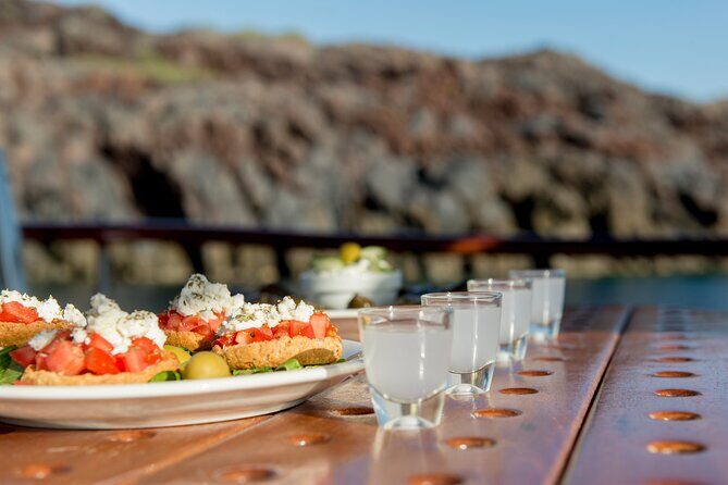 Santorini Caldera Sunset Traditional Cruise with Meal and Drinks - Mesa Pigadia Beach and the rocky pass-by moments