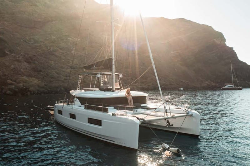 Santorini: Majestic Catamaran Cruise with Meal and Drinks - The first swimming phase: volcanic beaches and deck time