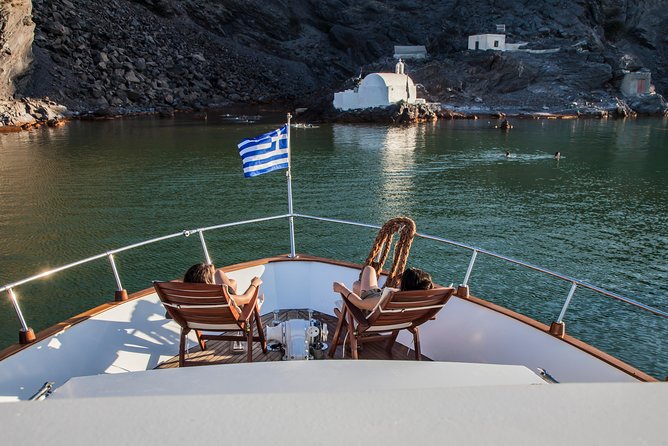 Santorini: Motor Yacht Sunset Cruise with 5-Course Dinner - Leaving Vlihada for Santorini’s volcanic coast