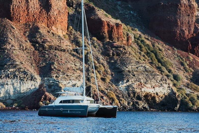 Santorini: Private Catamaran Cruise with BBQ Meal and Drinks - Thirassia and the view of Manolas: calmer water, quieter scenery